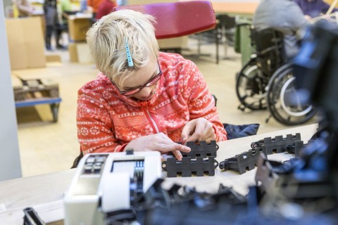 eine Frau im Rollstuhl, die etwas zusammenbaut