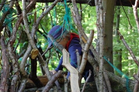 Kind beim Bau einer Hütte oder eines Unterstandes im Wald