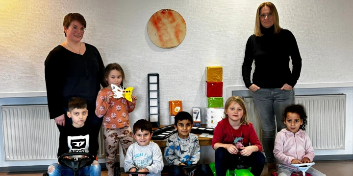 Bild von der Spenden&uuml;bergabe: Doris Ellermann, Leiterin des Sprachheilkindergartens mit 6 Kindern auf den Bobbycars