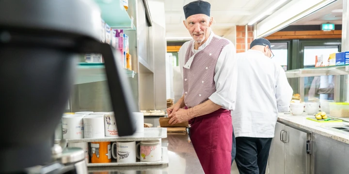 Zwei Mitarbeiter hinter der Essensausgabe in der BBS Sch&ouml;lerberg.
