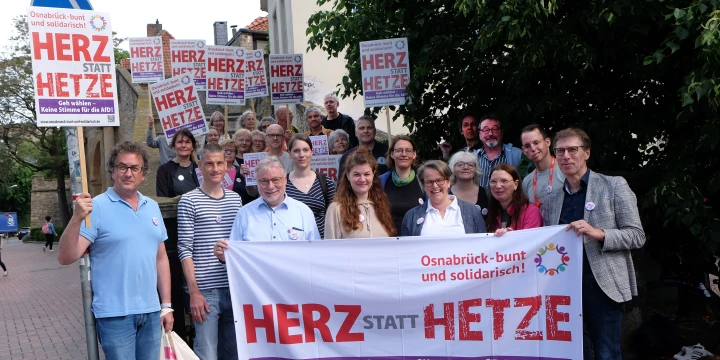 Viele Menschen halten Plakate und Banner mit der Aufschrift: "Herz statt Hetze" in die Luft.