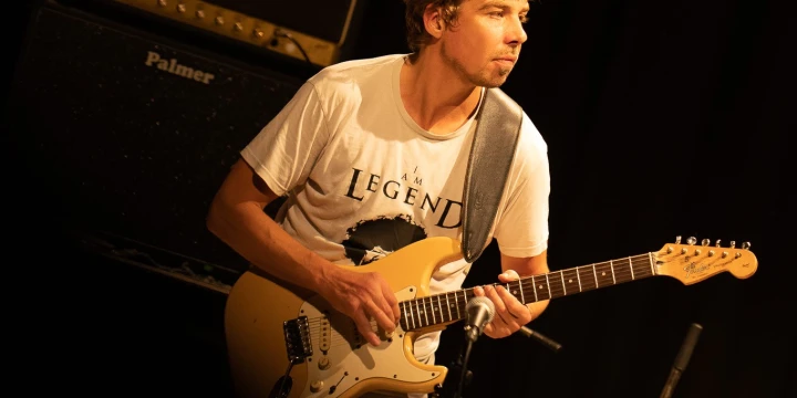 Ein Bild von dem Musiker Mischa Gohlke mit einer Gitarre.