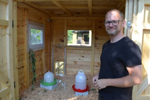 Ein Mitarbeitender zeigt den Stall von innen.