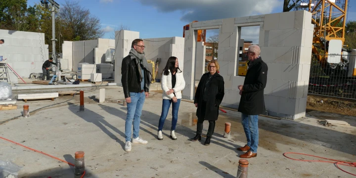 Zwei Frauen und zwei M&auml;nner stehen auf einer Baustelle