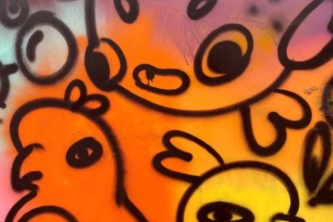 Bunte Graffiti-Darstellung mit stilisierten, comicartigen Tieren auf einem farbigen Hintergrund in Rosa, Orange und Gelb. Ein gro&szlig;es, kugelartiges, rosa Tier mit Punkten und offenen Augen dominiert die Mitte, umgeben von zwei vogel&auml;hnlichen, orange- und gelbfarbenen Figuren mit schwarzen Konturen.