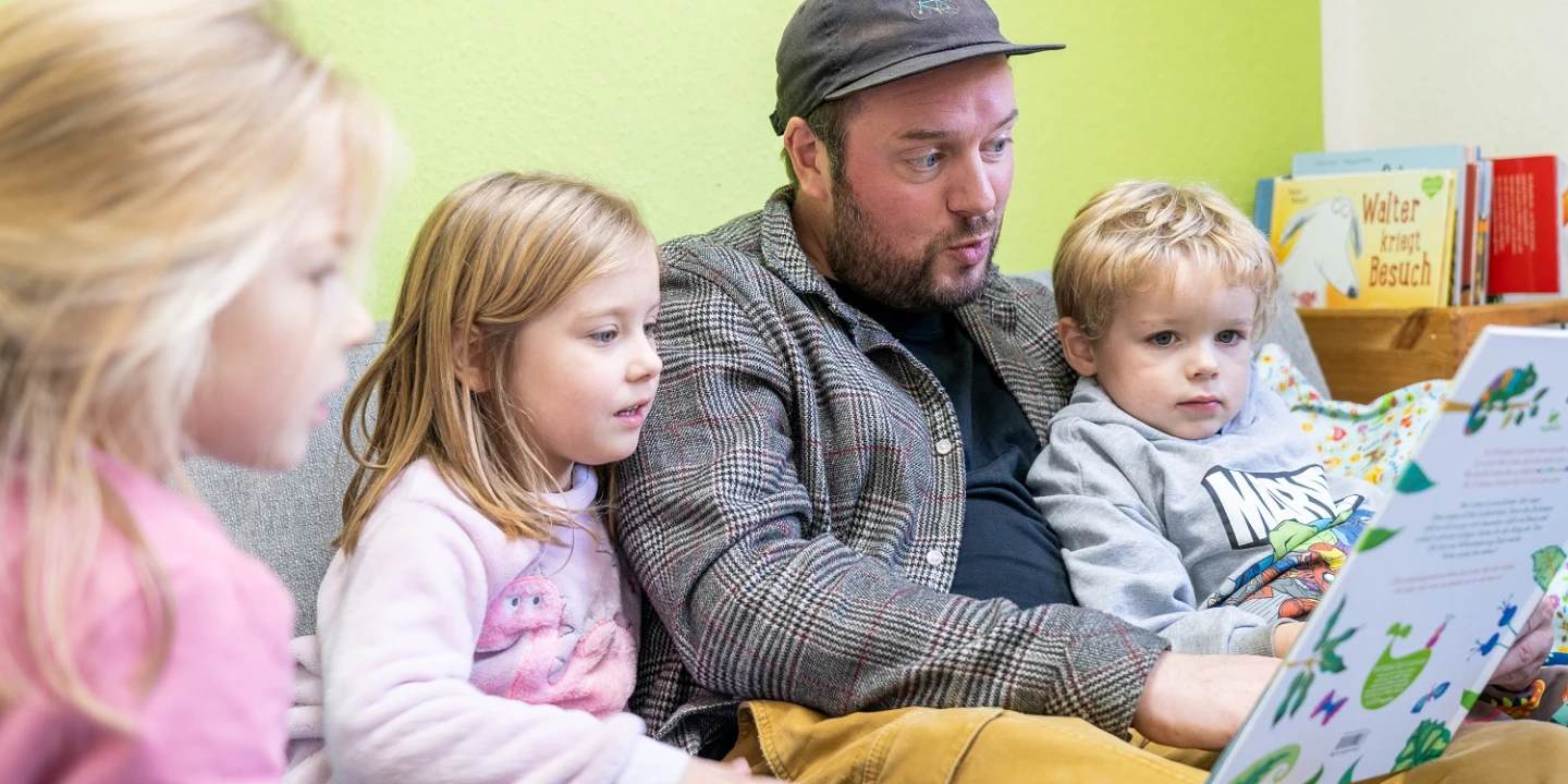 Ein Mann liest Kindern vor.
