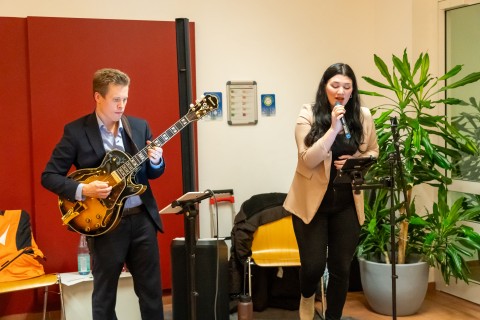 Ein Mann spielt Gitarre und eine Frau singt dazu.