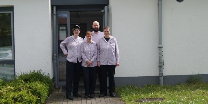 Die vier Mitglieder des inklusiven Team 360-Grand-Rundgang vor dem Eingang zur Cafeteria des Schulzentrums am Sonnenh&uuml;gel