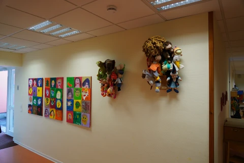 Bunte Wandgestaltung mit Bildern und Stofffiguren