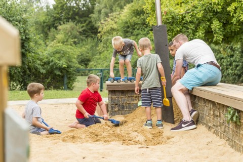 mehrere Kinder spielen im Sandkasten
